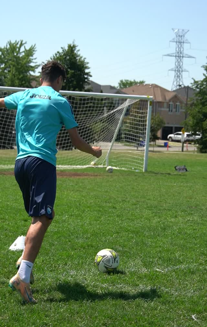Player striking the ball in front of goal